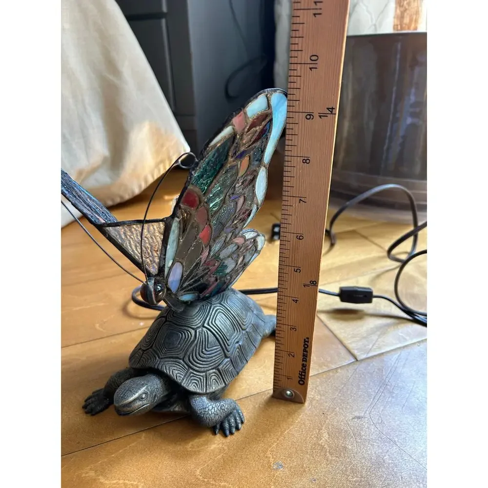 Vintage Tiffany style stained glass butterfly lamp resting on a brass turtle